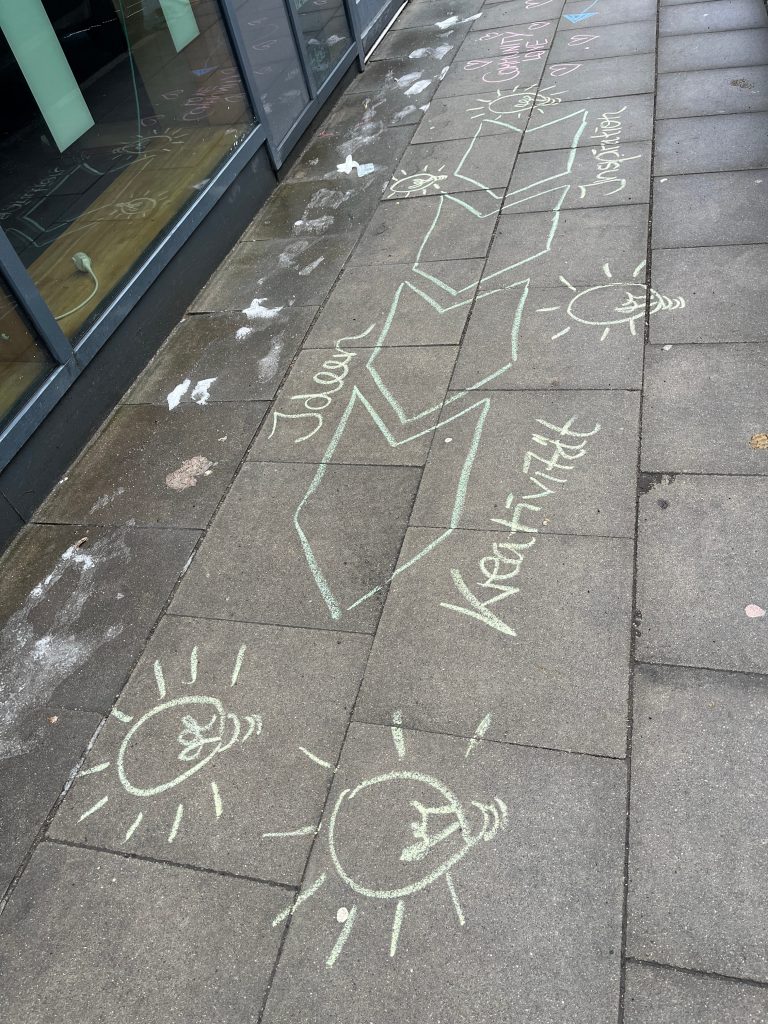 So findet jeder den Eingang zum Journaling Barcamp 2026 in Hamburg mit Kreideschrift und -Bildern auf den Gehwegplatten