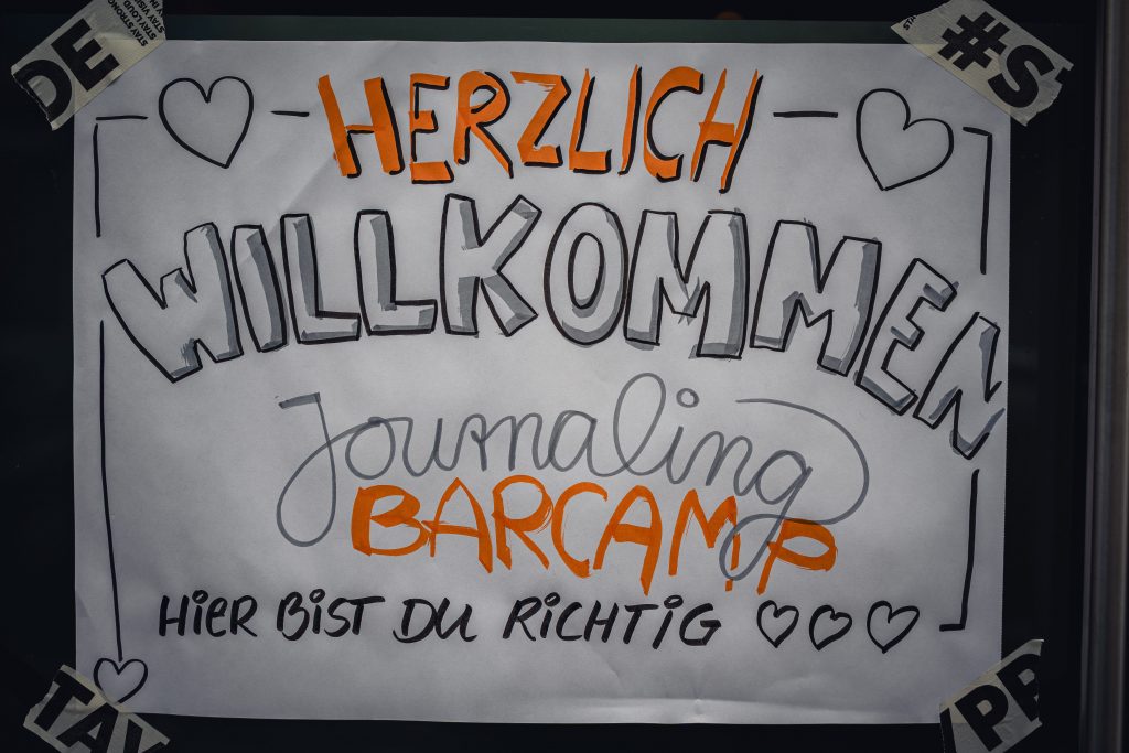 Vor dem Eingang zum Journaling Barcamp 2026 in Hamburg sagt uns Besuchern bereits ein Flipchart im Fenster "Hier bist du richtig"!