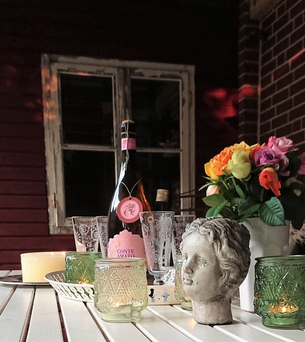 Gedeckter Tisch auf der Terrasse mit Kerzen und Blumen